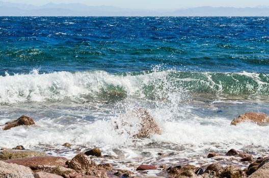 waves and splashes of sea surf and stones on the seashore
