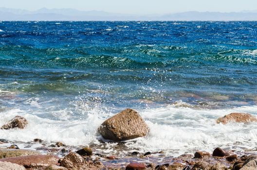 waves and splashes of sea surf and stones on the seashore