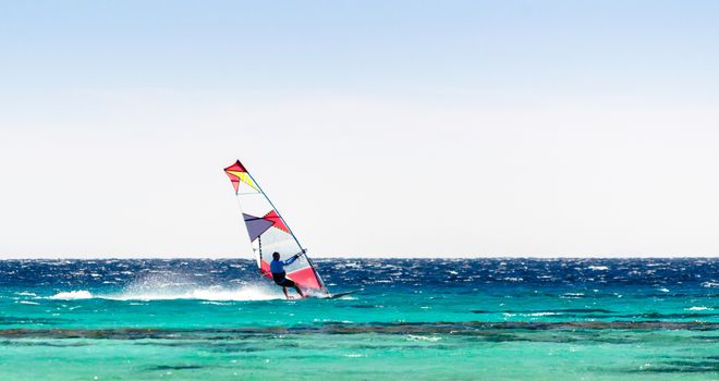 surfer rides in the Red Sea on the background of a clear sky in Egypt. Dahab