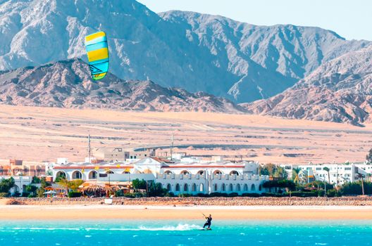 one surfer with a sail on a rocky shore and hotels in the Red Sea in Egypt