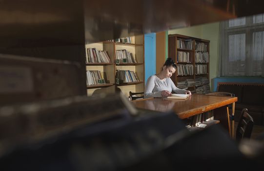 Student girl in a library. Looking at book