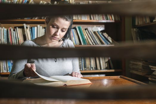 Student girl in a library. Looking at book