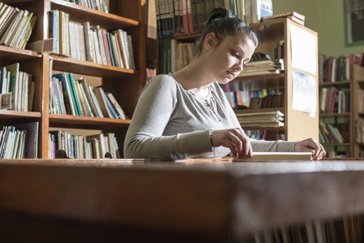 Student girl in a library. Looking at book