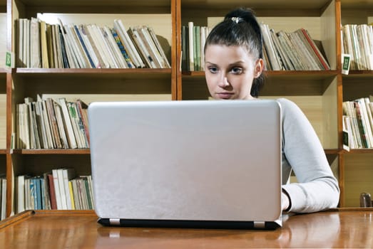 Student girl and laptop in a vintage library