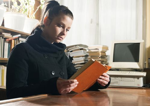 Student girl in a library. Looking at book