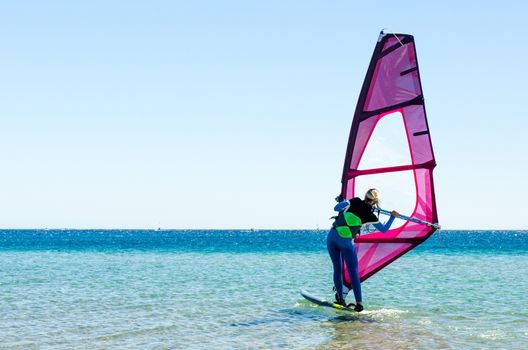 young girl windsurfer beginner learns to ride in the sea in Egypt Dahab