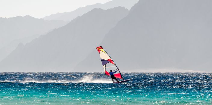 windsurfer rides on a background of high rocky mountains in Egypt Dahab