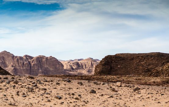 mountains in the desert against the blue sky and white clouds