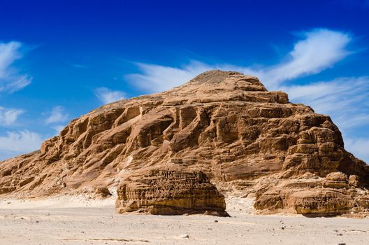 high rocky mountains against the blue sky and white clouds in the desert in Egypt Dahab South Sinai