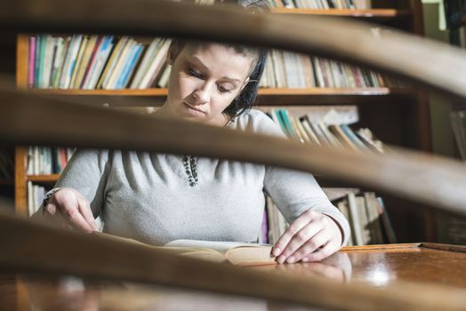 Student girl in a library. Looking at book