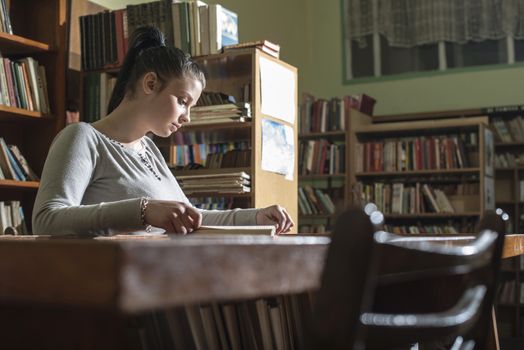 Student girl in a library. Looking at book