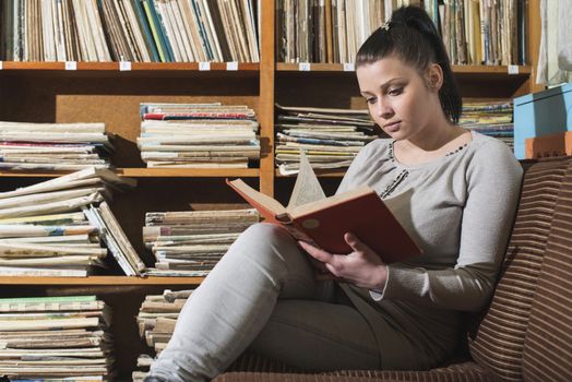 Student girl in a library. Looking at book