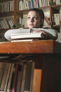 Student girl in a library. Looking at book