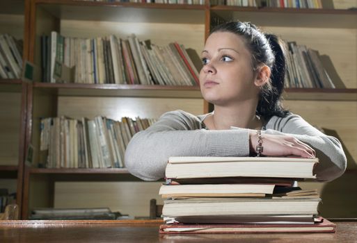 Student girl in a library. Looking at book