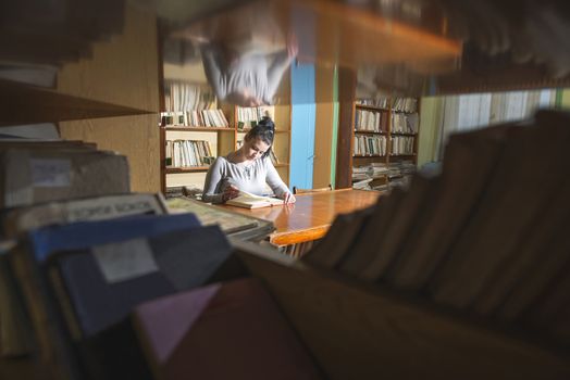 Student girl in a library. Looking at book