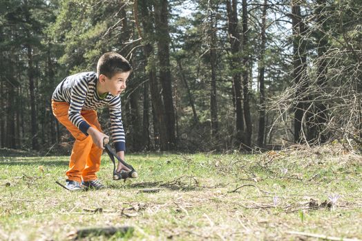 Child play with sling toy in the forest.