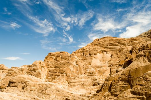 high rocky mountains in the desert against the blue sky and white clouds in Egypt Dahab