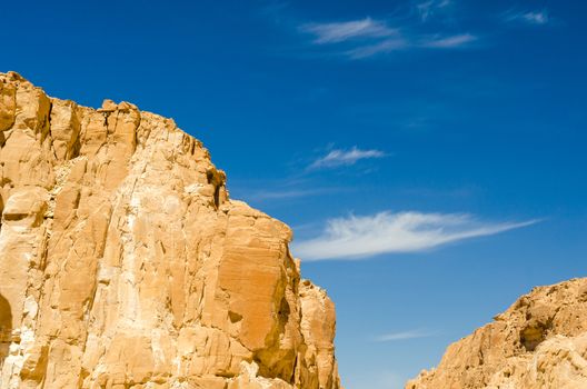 high rocky mountains against the blue sky and white clouds in the desert in Egypt Dahab