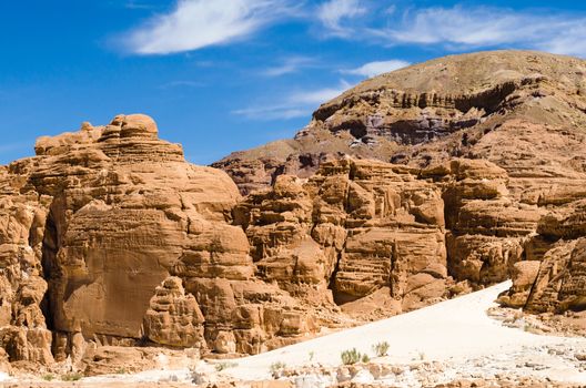 high rocky mountains against the blue sky and white clouds in the desert in Egypt Dahab South Sinai