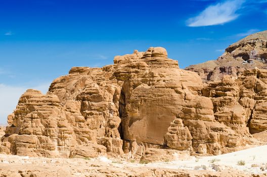 high rocky mountains against the blue sky and white clouds in the desert in Egypt Dahab South Sinai