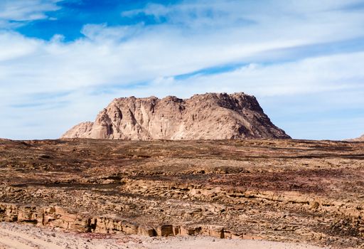 high mountain in the desert against the blue sky and white clouds