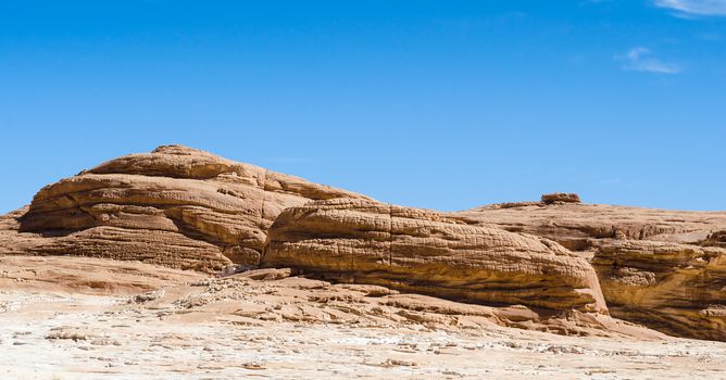 high rocky mountains against the blue sky and white clouds in the desert in Egypt Dahab South Sinai
