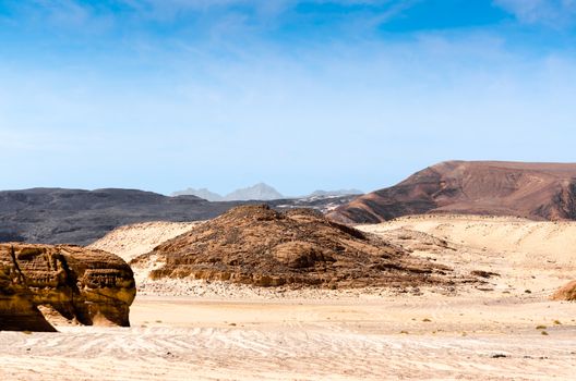 high rocky mountains against the blue sky and white clouds in the desert in Egypt Dahab South Sinai