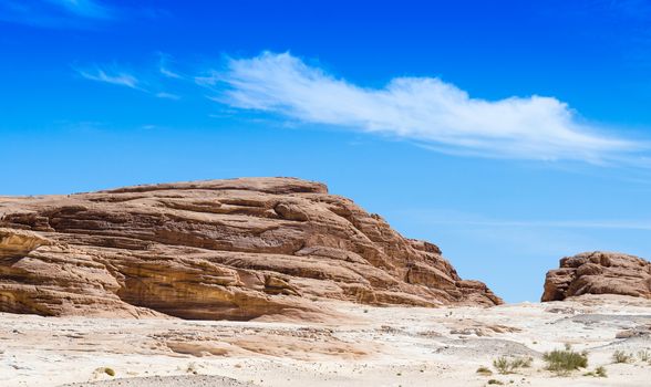 high rocky mountains against the blue sky and white clouds in the desert in Egypt Dahab South Sinai