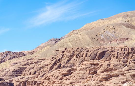 high rocky mountains against the blue sky and white clouds in the desert in Egypt Dahab South Sinai