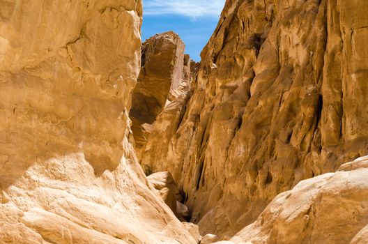 high rocky mountains against the blue sky and white clouds in the desert