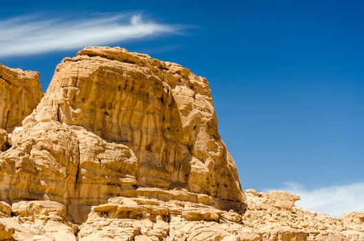 high rocky mountains in the desert against the blue sky and white clouds