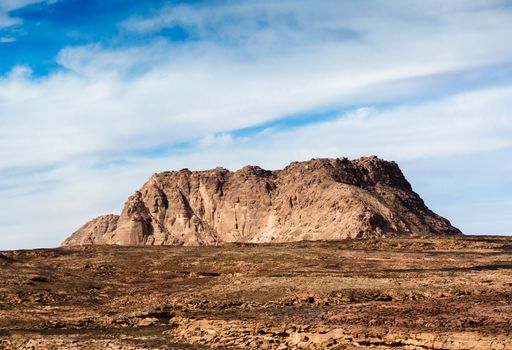 high mountain in the desert against the blue sky and white clouds