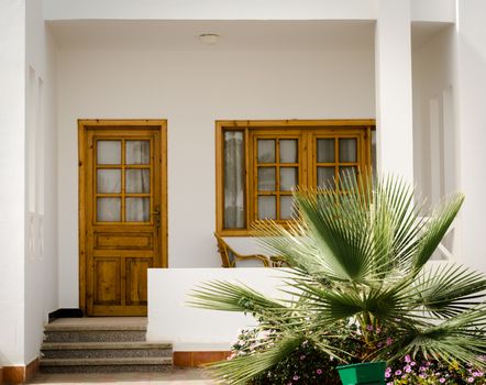 white resort house with a green tropical plant nearby