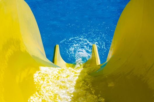water flowing on a bright yellow hill on the background of the black pool
