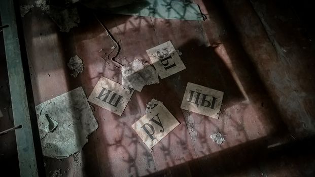 russian word rupitsy on sheets of paper on the floor in an abandoned house in Chernobyl
