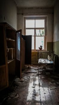 room with a window with a bed and a wardrobe in an abandoned house in Chernobyl