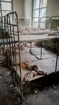 empty children's beds in an abandoned kindergarten house with peeling walls in Chernobyl