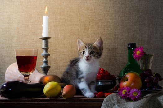 rustic still life with kitten pumpkin grapes dog rose green bottle grapes viburnum apples glass and tin glasses and a burning candle in a candlestick