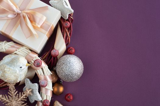 Christmas background with gift and ornaments on purple paper background with copy space for text