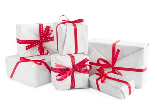 Heap of similar Christmas silver gift boxes with red ribbon decor isolated on white background