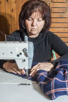 Woman sewing on white sewing machine. 