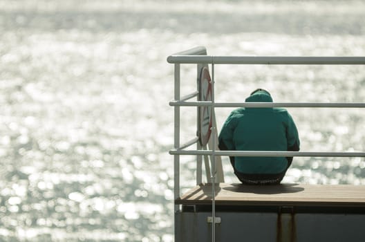 Man sitting in front of the sea in silence and thinking