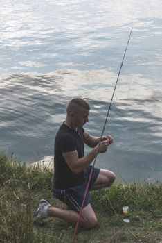 Man prepare rod for fishing. Mountain lake. Bulgaria