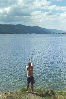 Man on fishing with rod. Mountain lake. Bulgaria