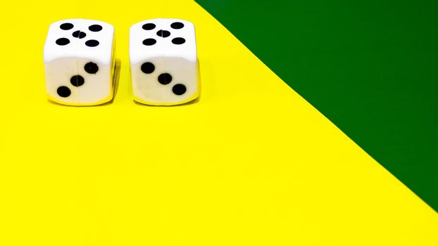 white and yellow dice on a combined green and yellow background