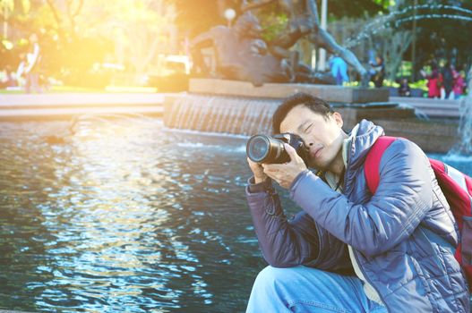 Asian Male tourist taking picture in the city of Sydney , Australia.