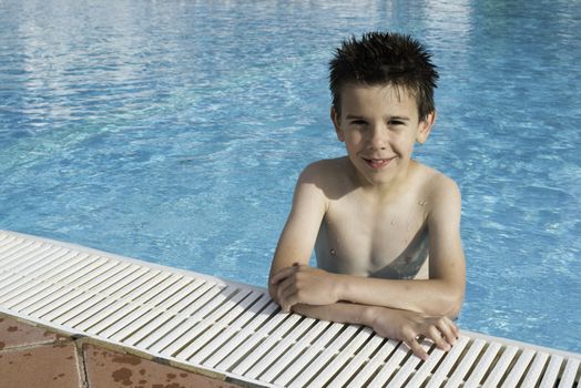 Child in swiming pool. Blue glasses