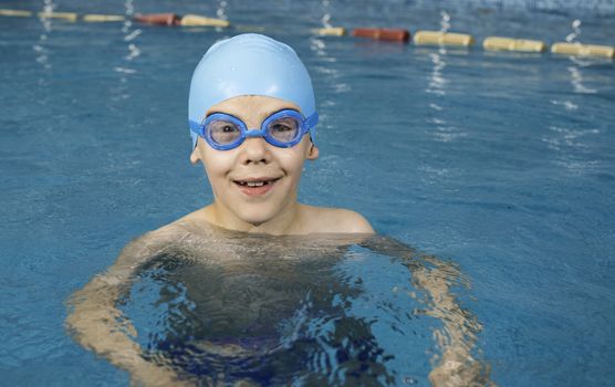 Little boy in swimming pool. Blue swimming pool.