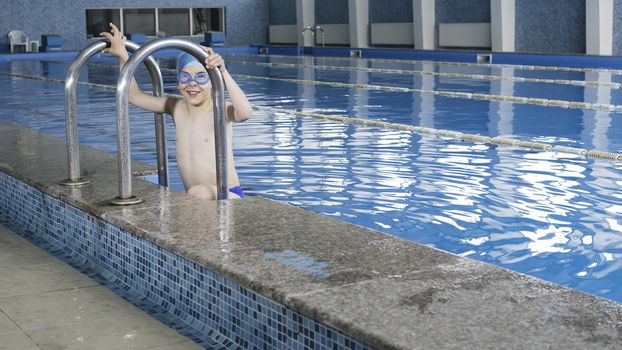 Little boy in swimming pool. Blue swimming pool.