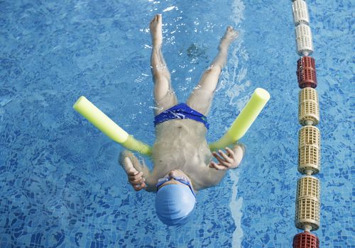 Child swimmer in swimming pool. Blue color swimming pool